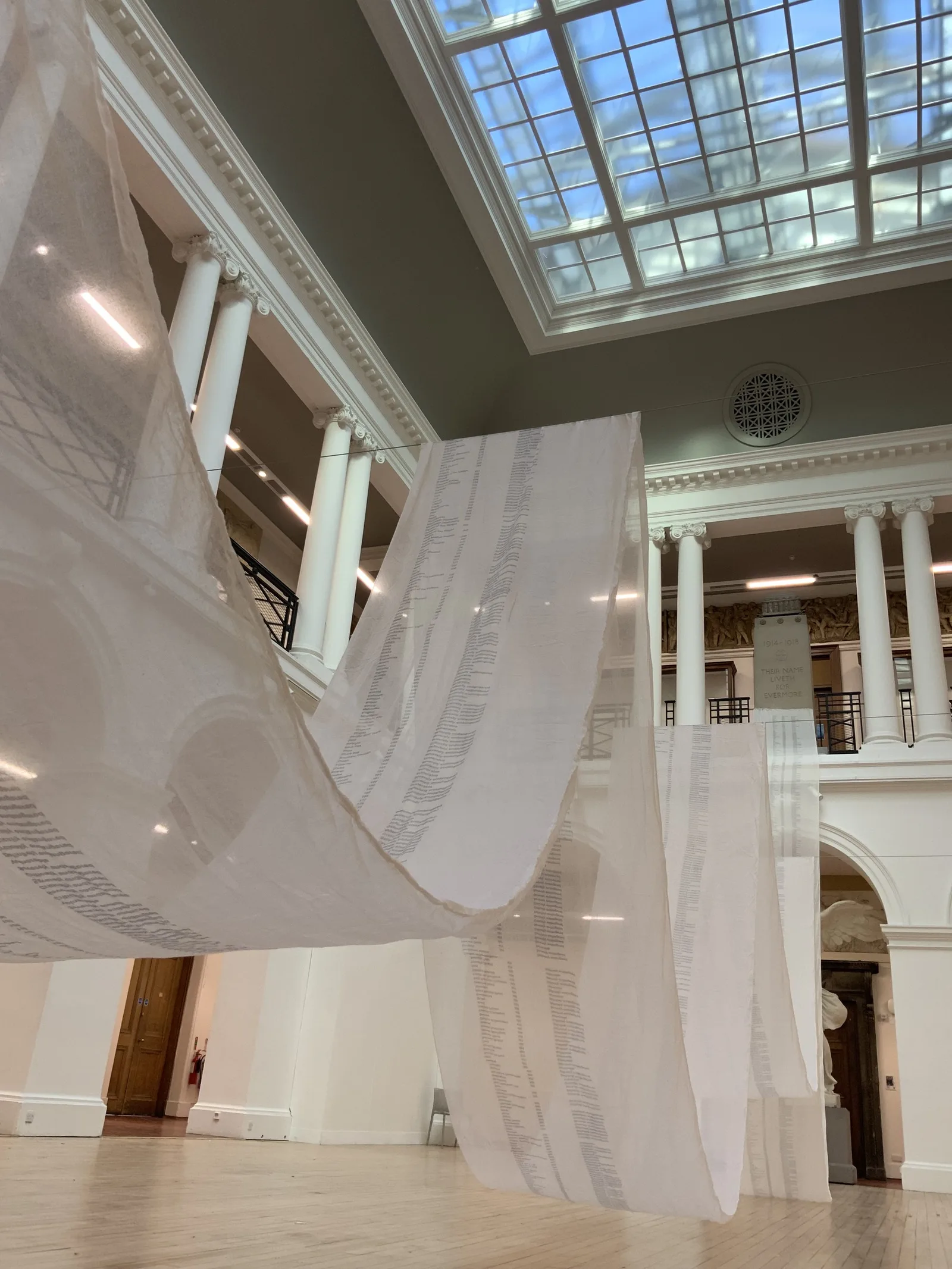 The printed muslin scroll hung through a gallery hall