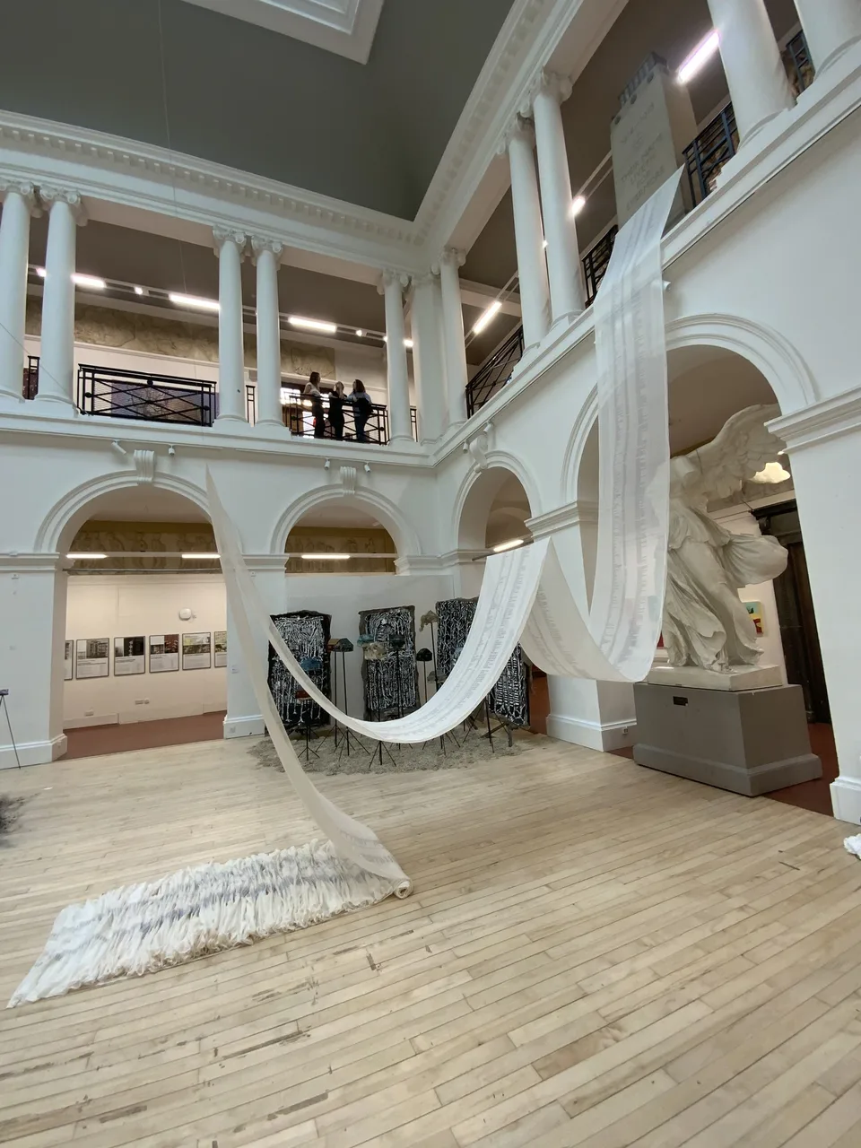 The scroll swagged through the arches of the sculpture court